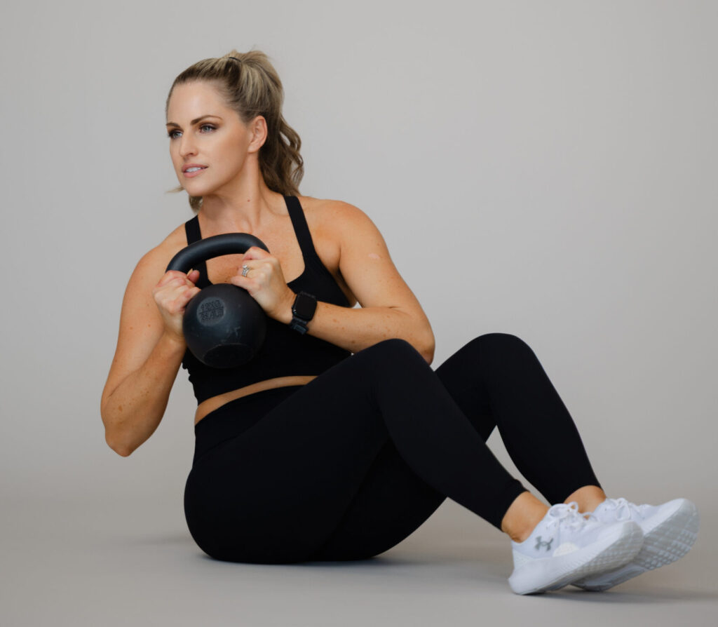 Woman doing a kettlebell strength workout for the free 4-week Sweat & Sculpt workout challenge.